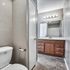 Elegant bathroom with a sleek vanity, modern lighting, and a tiled floor, offering a refreshing ambiance.