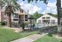 Charming apartment complex with a refreshing pool, surrounded by lush greenery and palm trees for a tropical feel.