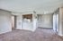 Inviting open-layout living space with plush carpeting, adjacent to a cozy kitchen and bright patio doors.