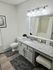 Chic bathroom featuring sleek granite countertops, modern lighting fixtures, and elegant decor in a serene neutral palette.