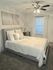 Serene bedroom with plush carpet, elegant decor, and cozy lighting, perfect for relaxation.