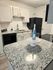 Modern kitchen with sleek granite countertops, elegant white cabinetry, and stylish appliances perfect for culinary creativity.