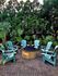 Inviting outdoor patio featuring turquoise Adirondack chairs arranged around a cozy fire pit, surrounded by lush greenery.