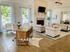 Elegant living room with stylish furniture, cozy fireplace, and abundant natural light through large windows.