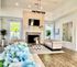 Elegant living room with high ceilings, chic fireplace, and natural light from large windows, featuring plush seating and stylish decor.