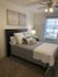 Inviting bedroom with a plush bed, elegant decor, and a sunlit window, creating a serene and cozy atmosphere.