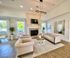 Elegant living room with plush sofas, modern fireplace, and large windows offering natural light and a scenic view.