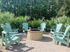 Inviting outdoor patio with stylish Adirondack chairs surrounding a modern fire pit, perfect for relaxing evenings.