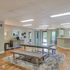 Spacious and inviting community room featuring modern decor, a large dining table on a plush rug, and a stylish beverage station.