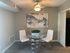 Contemporary dining nook with stylish glass table, modern artwork, and chic white chairs adding elegance to any home.
