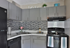 Charming modern kitchen with sleek gray cabinets, stylish mosaic backsplash, and stainless steel appliances, perfect for culinary creativity.