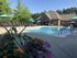 Inviting outdoor pool area with vibrant flowers and sun loungers, perfect for relaxation at a charming residential community.