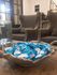 Inviting seating area with elegant armchairs and a rustic bowl of blue-packaged treats, creating a welcoming ambiance.
