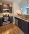 Modern kitchen with sleek granite countertops, stainless steel appliances, and elegant wooden cabinets, perfect for culinary enthusiasts.