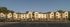 Charming modern apartment complex with elegant brickwork, surrounded by lush greenery and ample parking spaces.