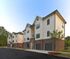 Modern apartment complex with elegant brick and siding exterior, offering spacious living in a serene suburban setting.
