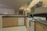 Modern kitchen with sleek wooden cabinets, spacious countertops, and high-quality appliances including stove and dishwasher.