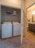 Bright and convenient laundry nook with modern washer and dryer, adjacent to a stylish bathroom, perfect for streamlined living.