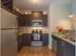 Modern kitchen with sleek granite countertops, stainless steel appliances, and rich dark wood cabinetry, featuring a cozy atmosphere with decorative touches.