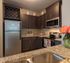 Chic modern kitchen with stainless steel appliances, elegant dark wood cabinets, and stylish granite countertops, enhanced by a vibrant flower arrangement.