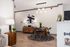 Chic dining area with modern wooden table, stylish pendant lighting, and contemporary art in a cozy apartment setting.