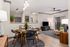 Chic open-concept dining and living area with modern decor, featuring a stylish dining table set, sleek TV stand, and access to a cozy balcony.