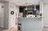Modern kitchen with granite countertop, sleek cabinetry, and stainless steel appliances, complemented by stylish lighting and a cozy pantry area.