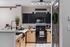 Modern kitchen with sleek black appliances, stylish cabinetry, and elegant lighting, offering a functional and inviting cooking space.