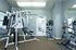 Modern apartment gym with state-of-the-art exercise equipment, featuring a sleek stationary bike and multifunctional weight machine.