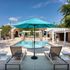 Luxurious outdoor pool area with sun loungers and turquoise umbrellas, perfect for relaxation and leisure.