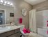 Charming bathroom with elegant flower wall art, modern vanity, and vibrant pink towels adding a splash of color.