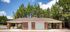 Charming brick building with car wash station nestled among lush green trees, offering convenient amenities in a serene setting.
