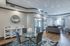 Bright, modern living room with chic gray sofa, glass-top dining table, and stylish decor in an open-concept space.