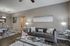 Elegantly designed living room with plush gray sofa, modern glass tables, and chic decor, creating a cozy yet sophisticated ambiance.