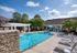 Inviting outdoor pool area with lounging chairs, shaded pergola, and vibrant blue skies, perfect for relaxation and leisure.