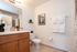 Elegant bathroom with modern vanity, decorative lighting, and luxurious towels, accented by tasteful artwork.
