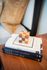 Chic wooden decor on a stylish stack of fashion books, enhancing elegant living space.