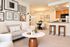 Chic open-plan living area featuring stylish wall art, a cozy sofa, and a modern kitchen with bar seating.