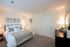 Charming bedroom featuring a plush bed with elegant linens, soft lighting, and tasteful wall art, creating a cozy and inviting atmosphere.