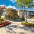 Inviting apartment entrance surrounded by lush landscaping and vibrant flowers, showcasing a welcoming community atmosphere.