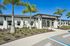 Bright and inviting exterior of a modern building with palm trees and future resident parking, perfect for welcoming new tenants.