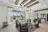 Elegant apartment lobby featuring stylish seating area with modern black chairs, chic lighting fixtures, and large windows providing abundant natural light.