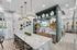 Modern communal kitchen with sleek marble countertops, stylish pendant lighting, and artistic decor, ideal for entertaining.