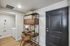 Chic entryway with elegant black door, stylish bookcase, cozy workspace, and convenient laundry area, perfect for modern living.