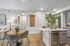 Inviting modern kitchen and dining area with elegant decor and cozy lighting, featuring a chic dining table and stylish kitchen island with built-in wine cooler.
