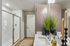 Contemporary bathroom featuring a sleek glass shower, elegant vanity with a large mirror, and stylish d&eacute;cor elements including modern vases with lush green plants.