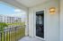 Inviting apartment balcony view overlooking serene waterfront and modern residential complex, perfect for relaxation.