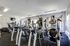 Modern fitness center filled with a variety of cardio and strength equipment, large windows offering abundant natural light.
