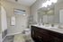 Inviting bathroom boasts double sinks, sleek dark wood vanity, and elegant decor for a refined touch.