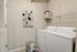 Bright and efficient laundry room with modern washer and dryer, featuring organized shelving and stylish wall decor.